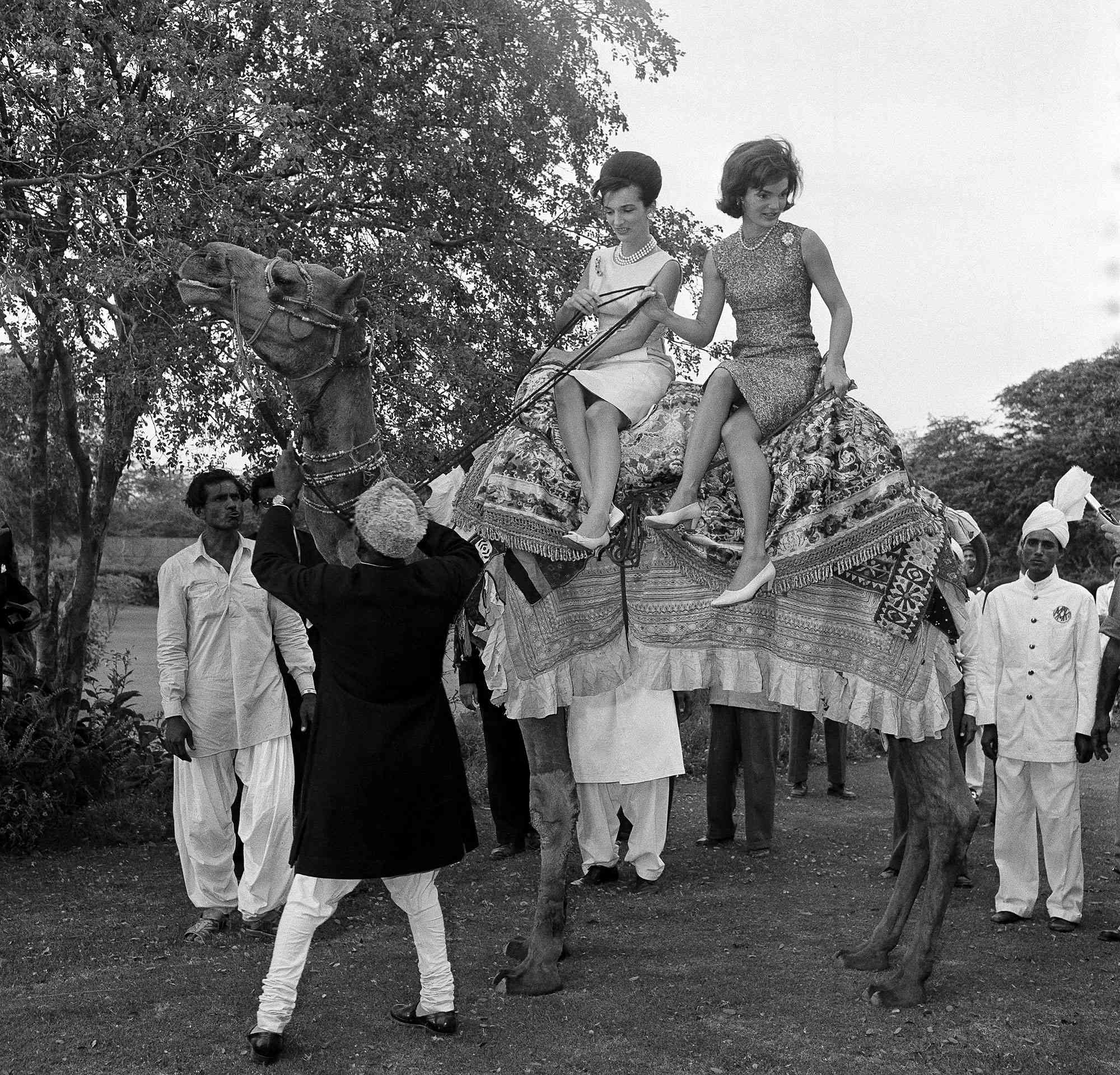 John F. Kennedy and Jacqueline Kennedy walk alongside each other at their outdoor wedding reception in Newport, R.I., in 1953