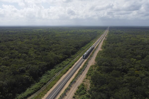 The inaugural train with President Andrés Manuel López Obrador on board passes near Chochola, Quintana Roo State, Mexico, Friday, Dec. 15, 2023. Mexico