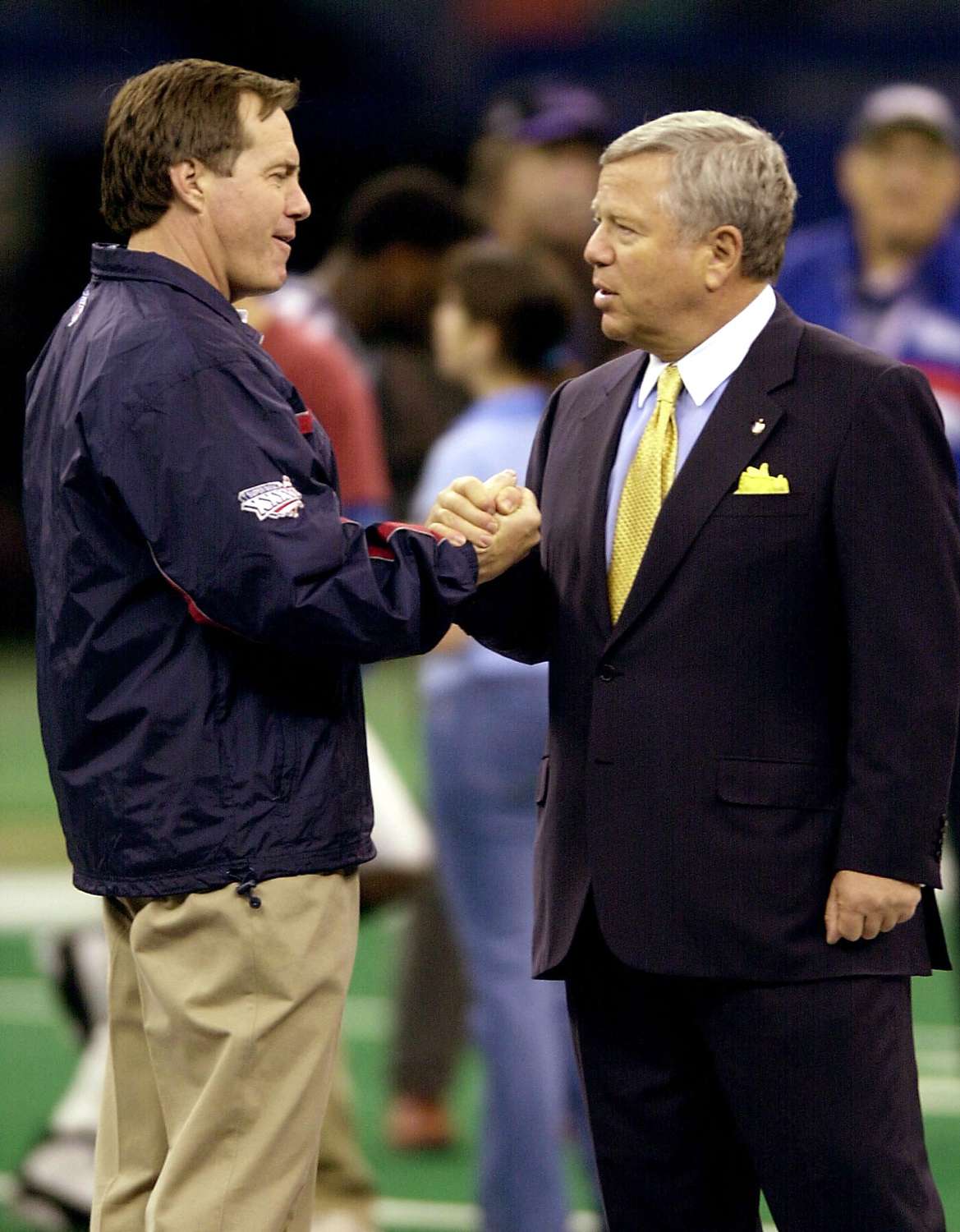 New England Patriots Head Coach Bill Belichick (L) shakes the hand of team owner Bob Kraft at the Superdome in New Orleans, LA, 02 February, 2002 after they posed for an official team photo.