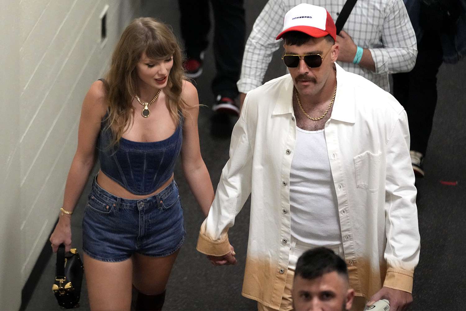 Kansas City Chiefs tight end Travis Kelce, right, and Taylor Swift hold hands following an NFL football game between the Chiefs and the Baltimore Ravens