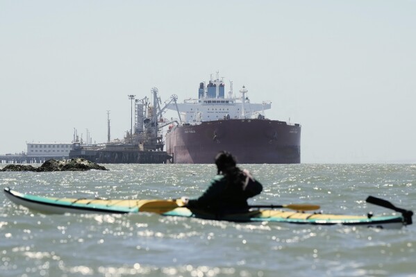 Juan Bay, president of the Waorani people of Ecuador, foreground, looks at an oil tanker docked at the Chevron Long Wharf, Thursday, June 19, 2025, in Richmond, Calif.