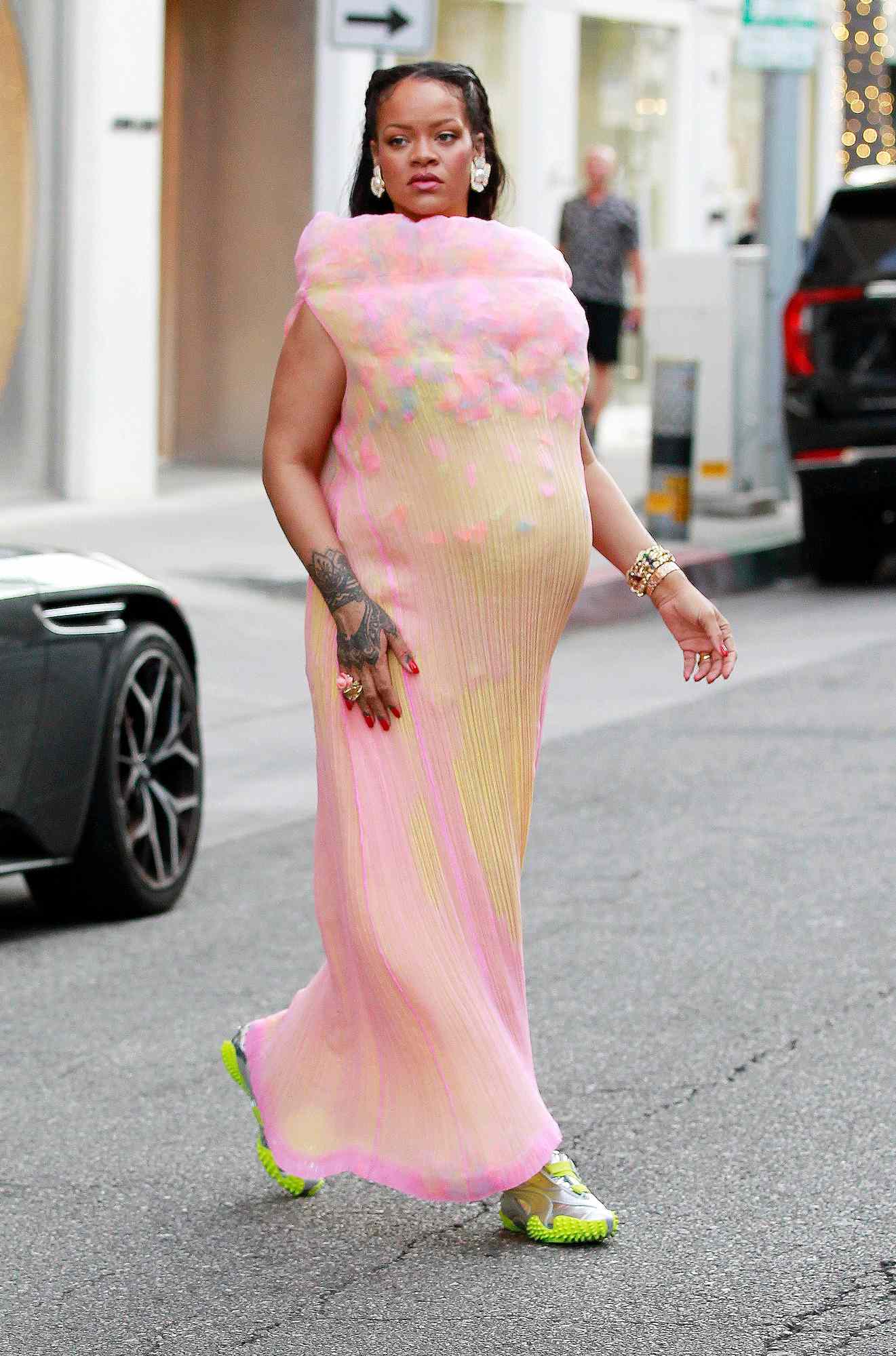 Rihanna shows off her baby bump in a semi sheer colorful dress and metallic silver Puma x Ottolinger sneakers in Los Angeles.