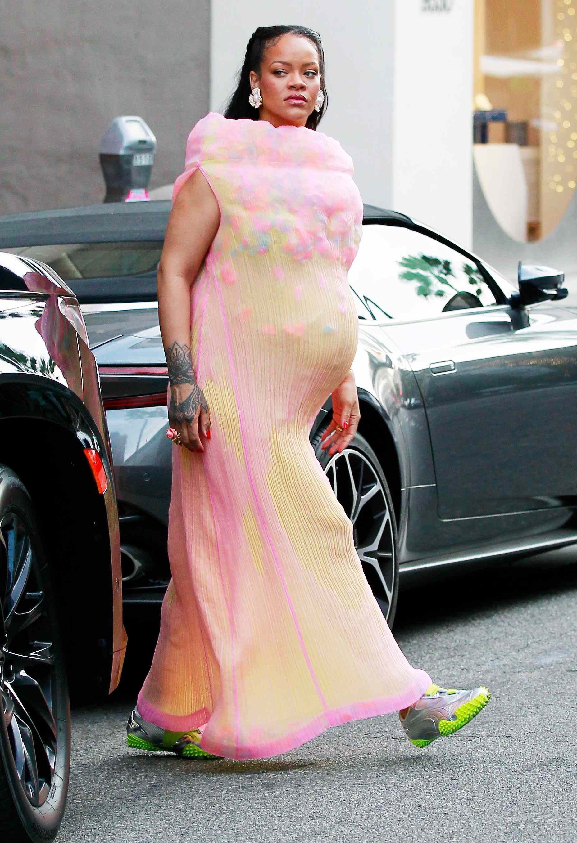 Rihanna shows off her baby bump in a semi sheer colorful dress and metallic silver Puma x Ottolinger sneakers in Los Angeles.