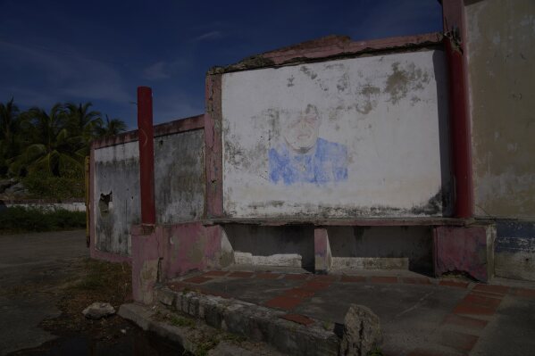 A barely visible mural of late President Hugo Chávez fades from a wall near the international port in Güiria, on Venezuela