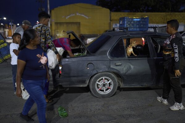 Shoppers load their goods into a car outside the municipal market in Cumana, capital of Venezuela
