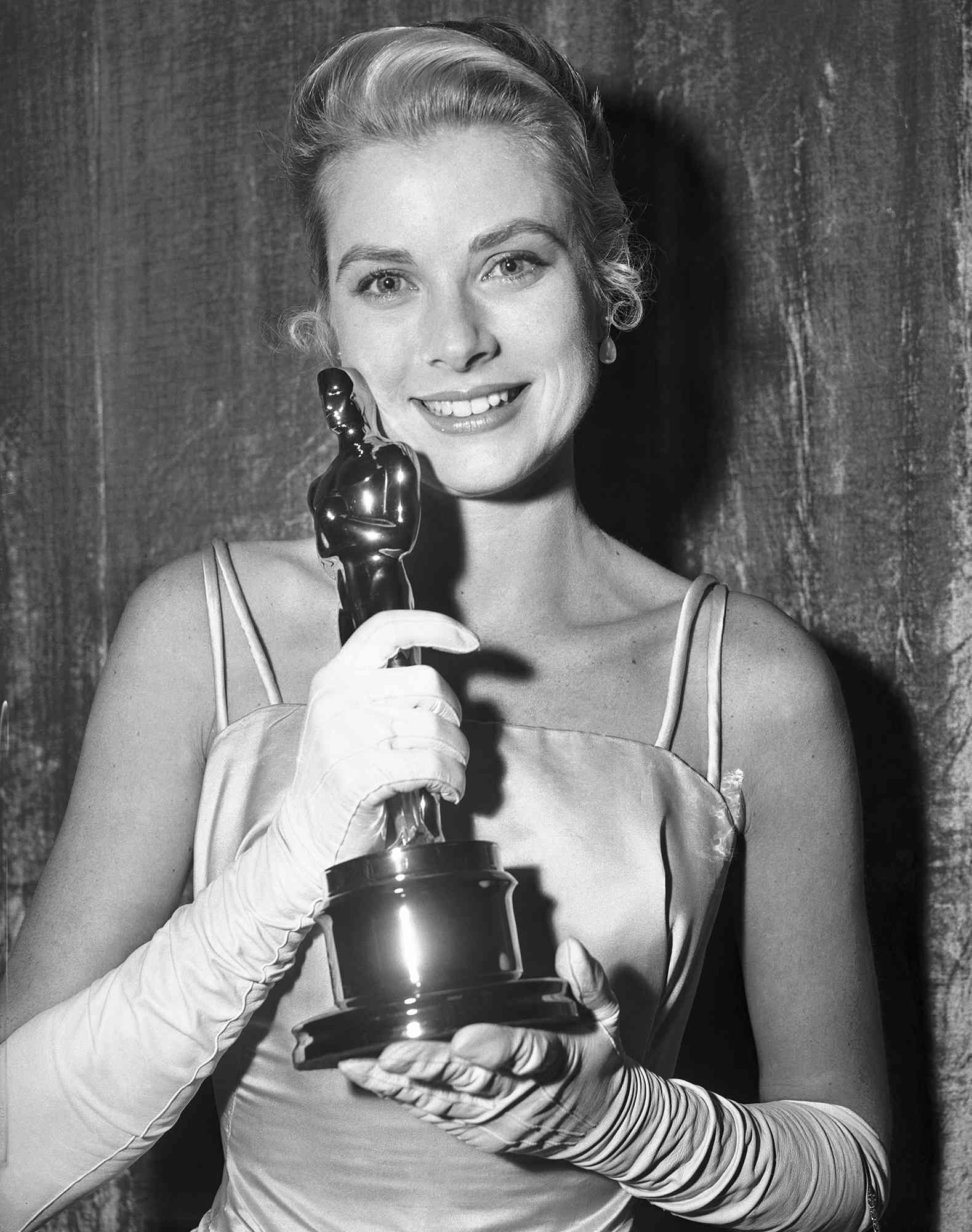 Grace Kelly hugging her Oscar after she was honored as the best actress of 1954