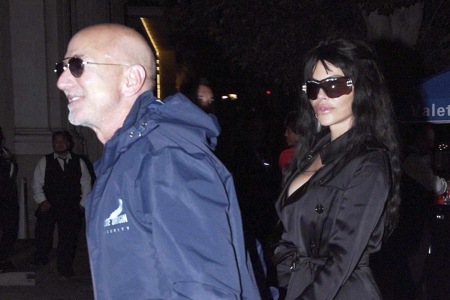 Jeff Bezos and Lauren Sanchez walking outdoors at night