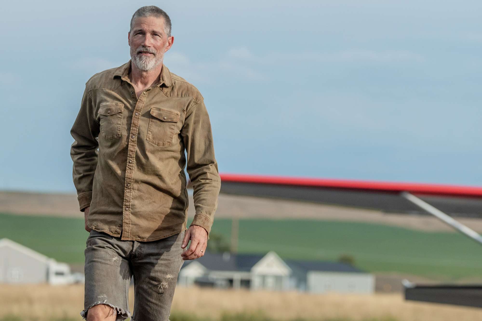 Matthew Fox outdoors with houses in the background