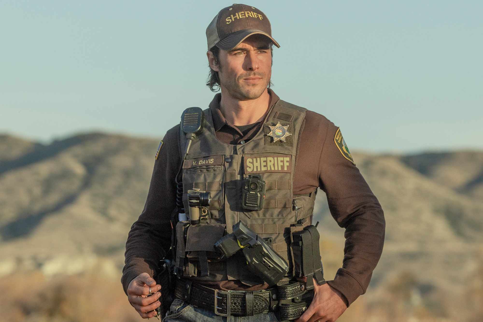 Ben Schnetzer dressed as a sheriff outdoors wearing law enforcement gear and a sheriff hat
