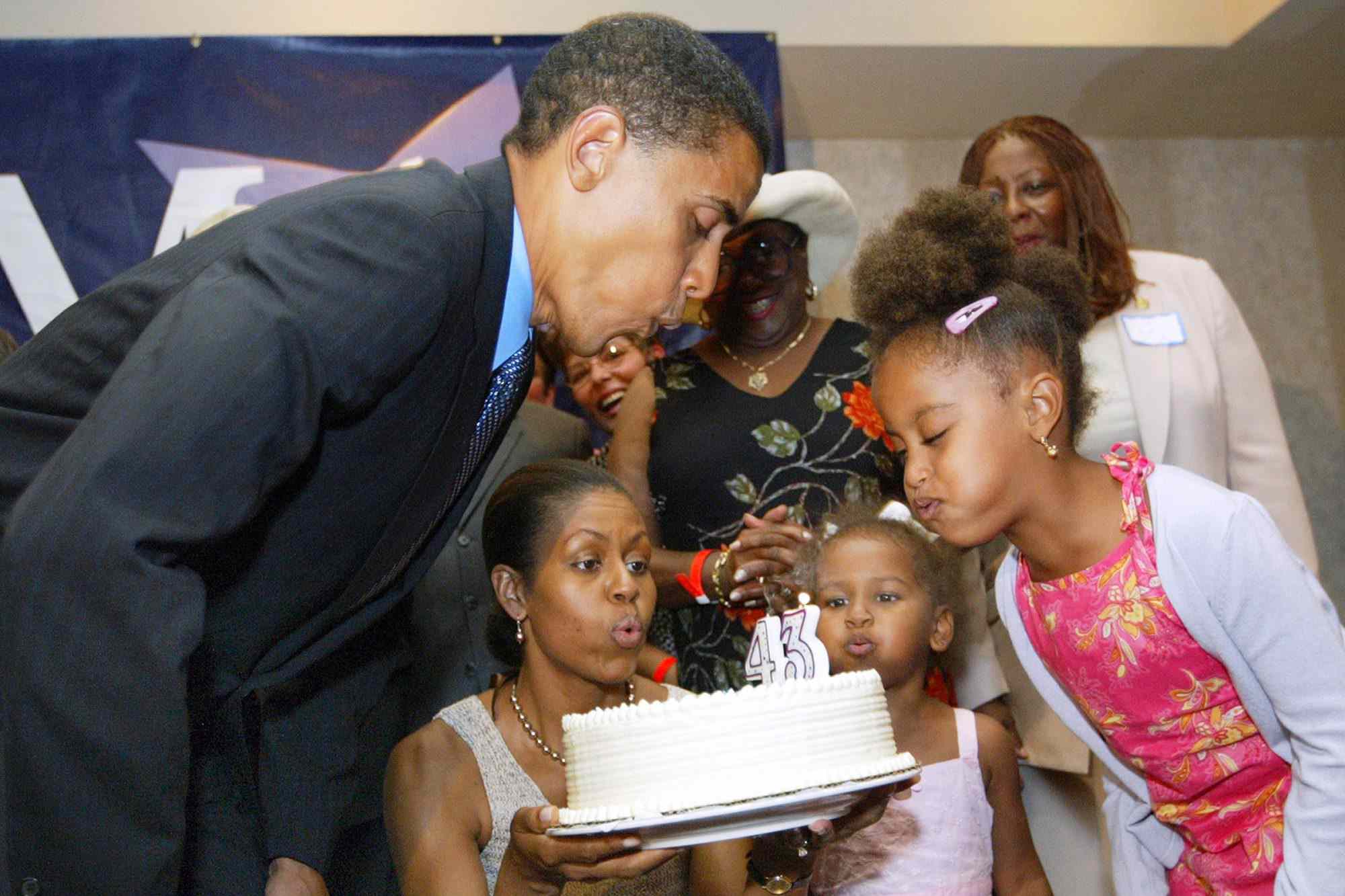 Barack Obama, Michelle Obama, Sasha Obama and Malia Obama blow out candles for Barack