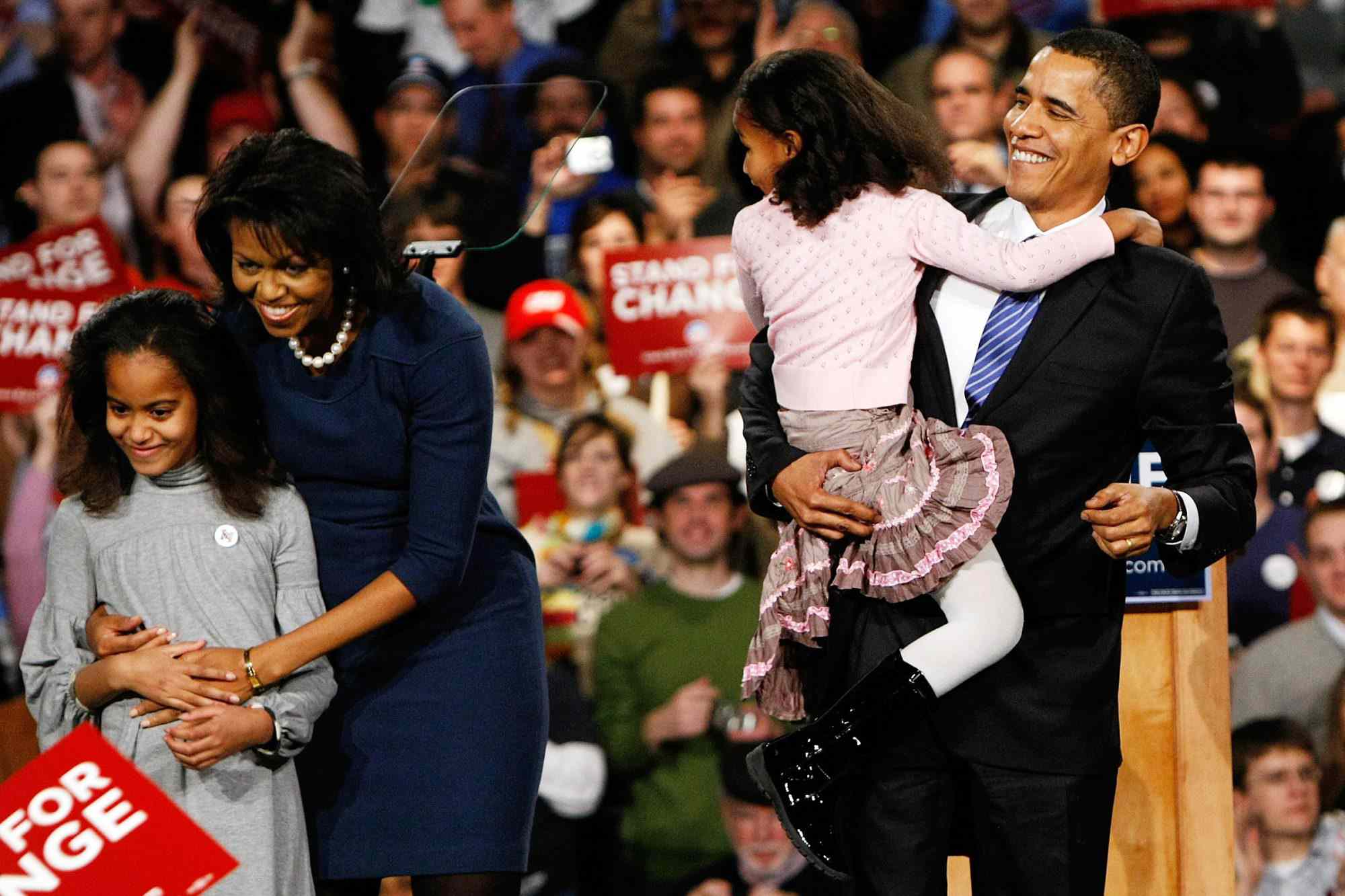 Barack Obama (right) holds his youngest daughter Sasha with his wife Michelle (center left) and daughter Malia while thanking supporters for his victory in the Iowa caucus on Jan. 3, 2008