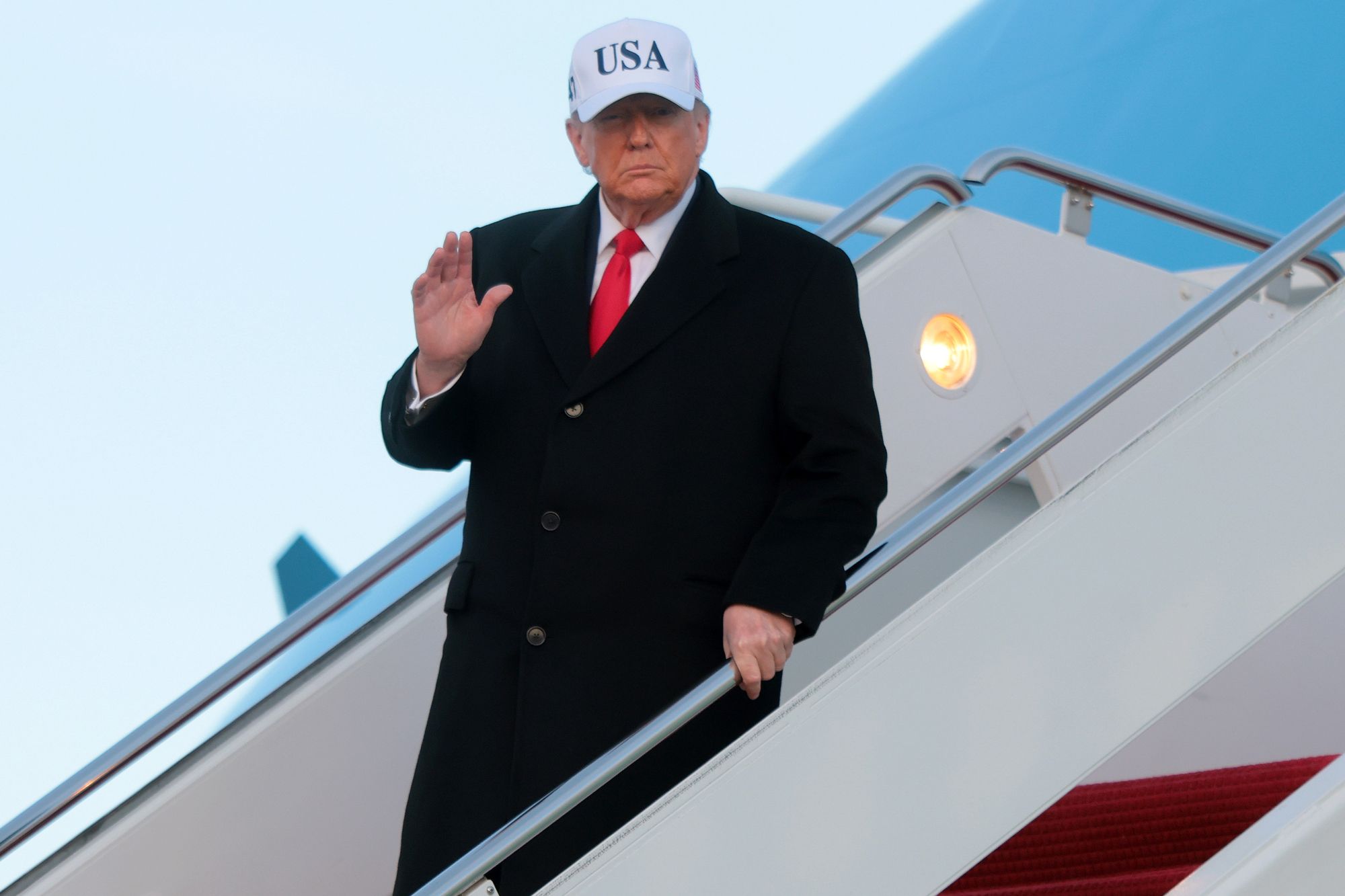 U.S. President Donald Trump waves after landing on Air Force One on January 13, 2026